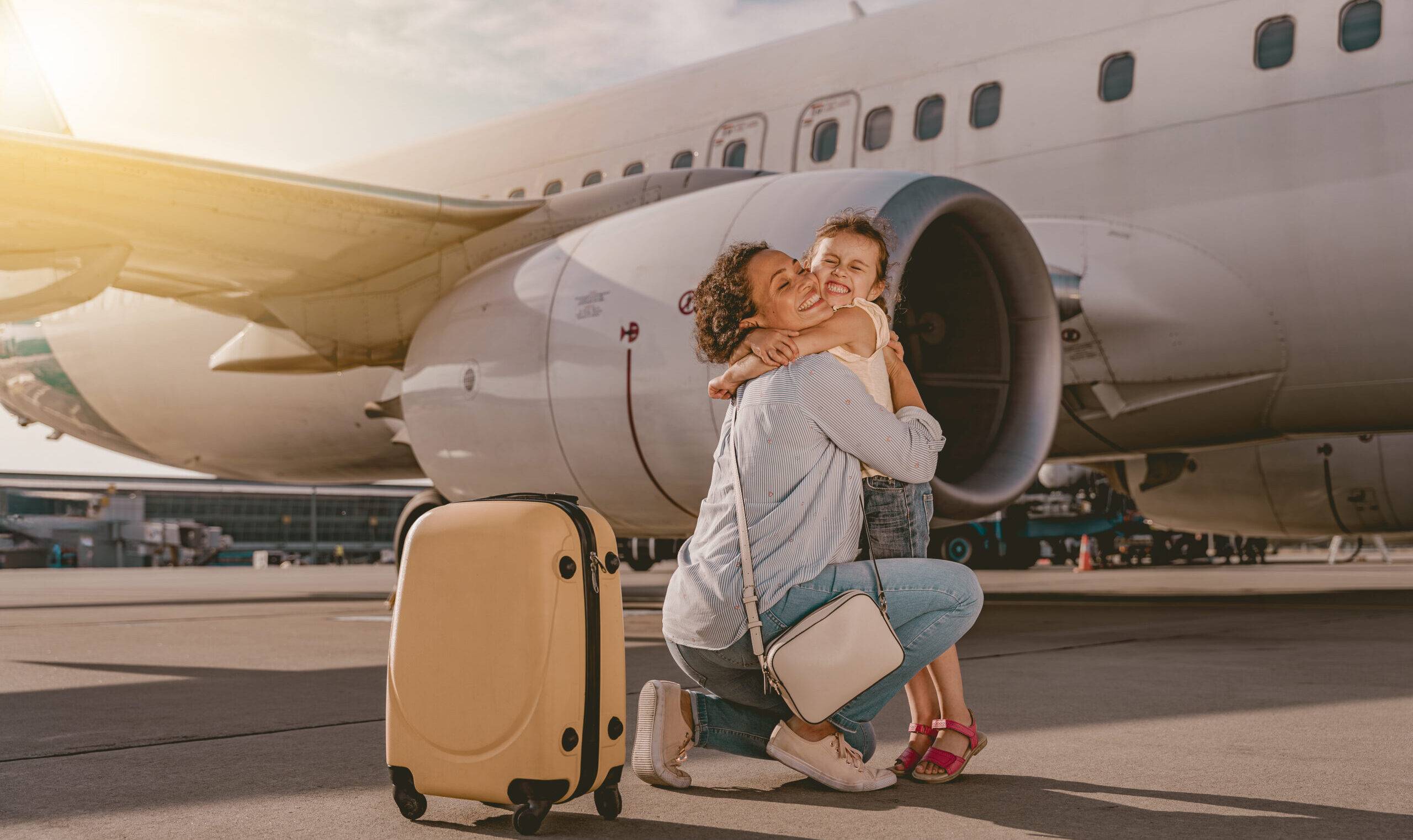 A Heartwarming Moment of Mom and Child Embracing at the Airport with an Airplane Nearby A Heartwarming Moment of Mom and Child Embracing at the Airport with an Airplane Nearby