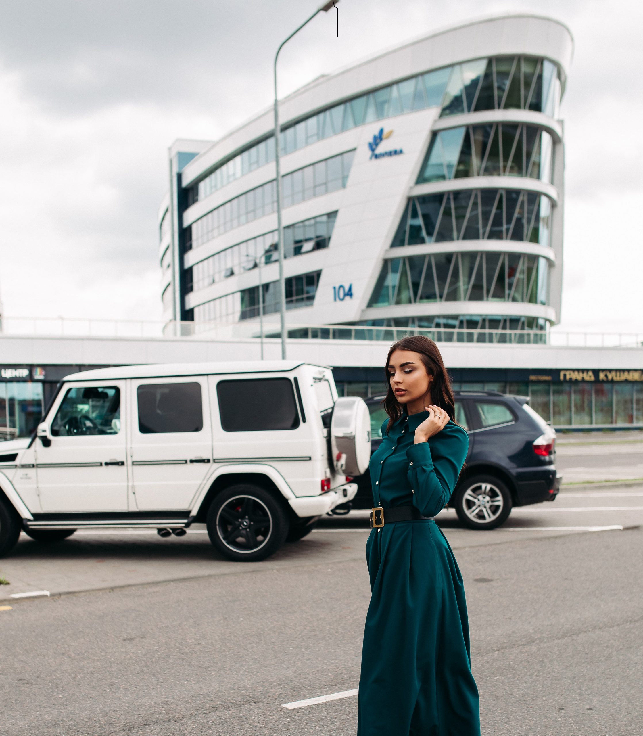 Stylish beautiful girl in dress walking in street.